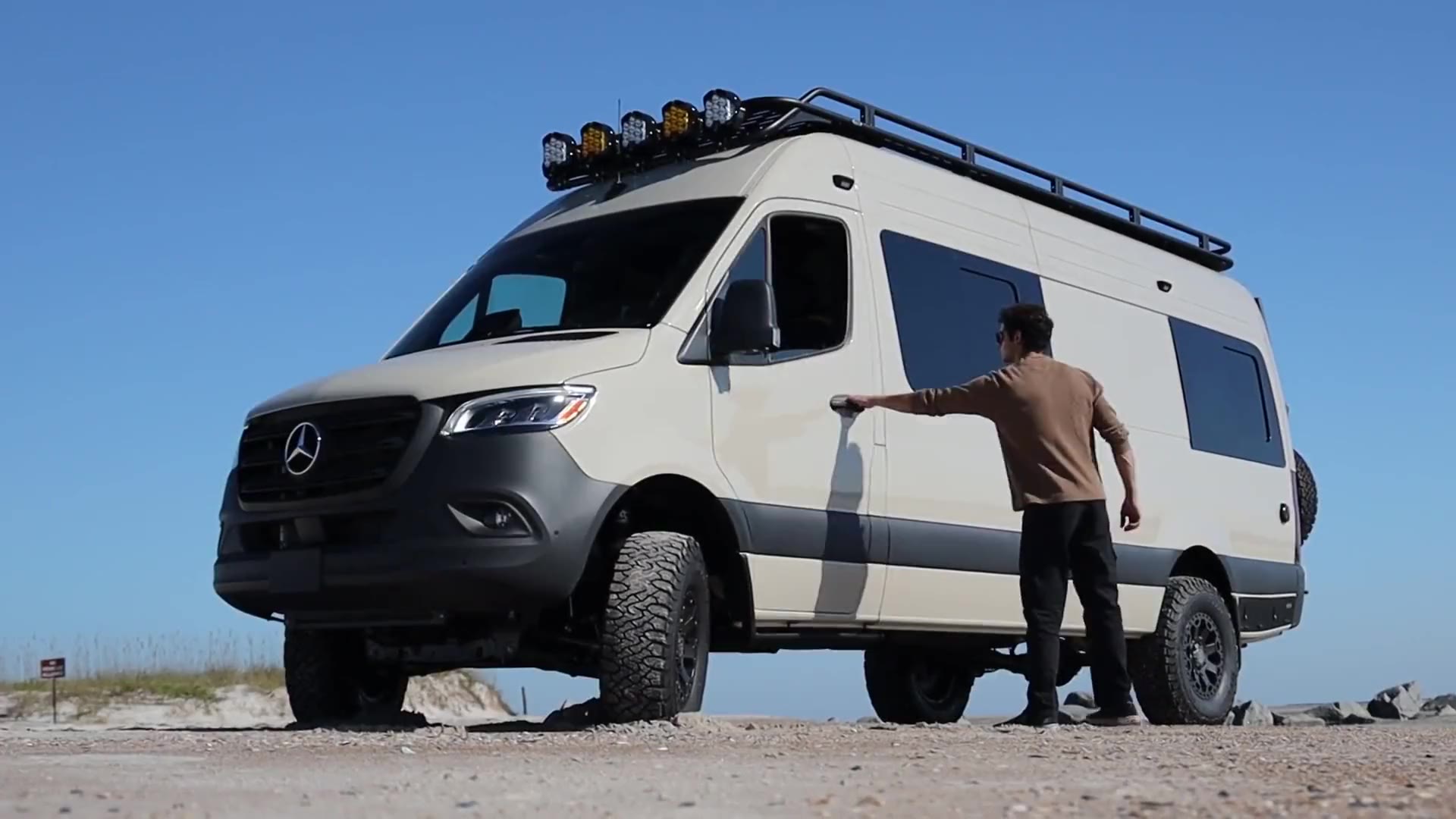 A sand-colored Beachside Sprinter camper van on the beach at Atlantic Beach, Florida