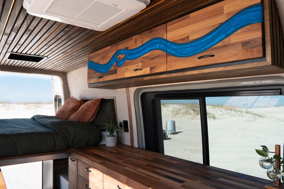 Custom cabinetry with a blue river inlay over the bed, looking out to the dunes